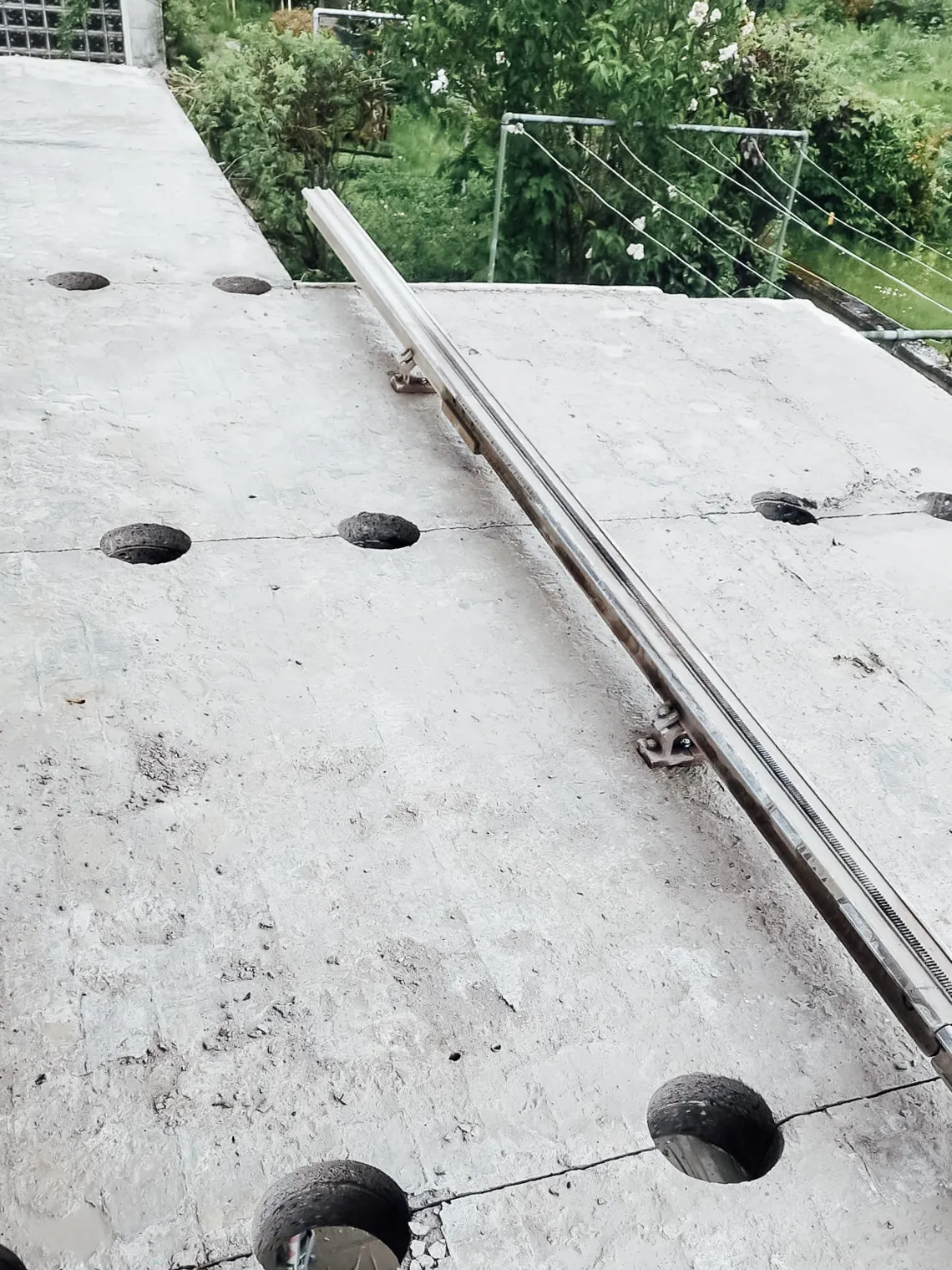 Betonboden mit zwei kleinen Kernbohrungen und verlegter Führungsschiene