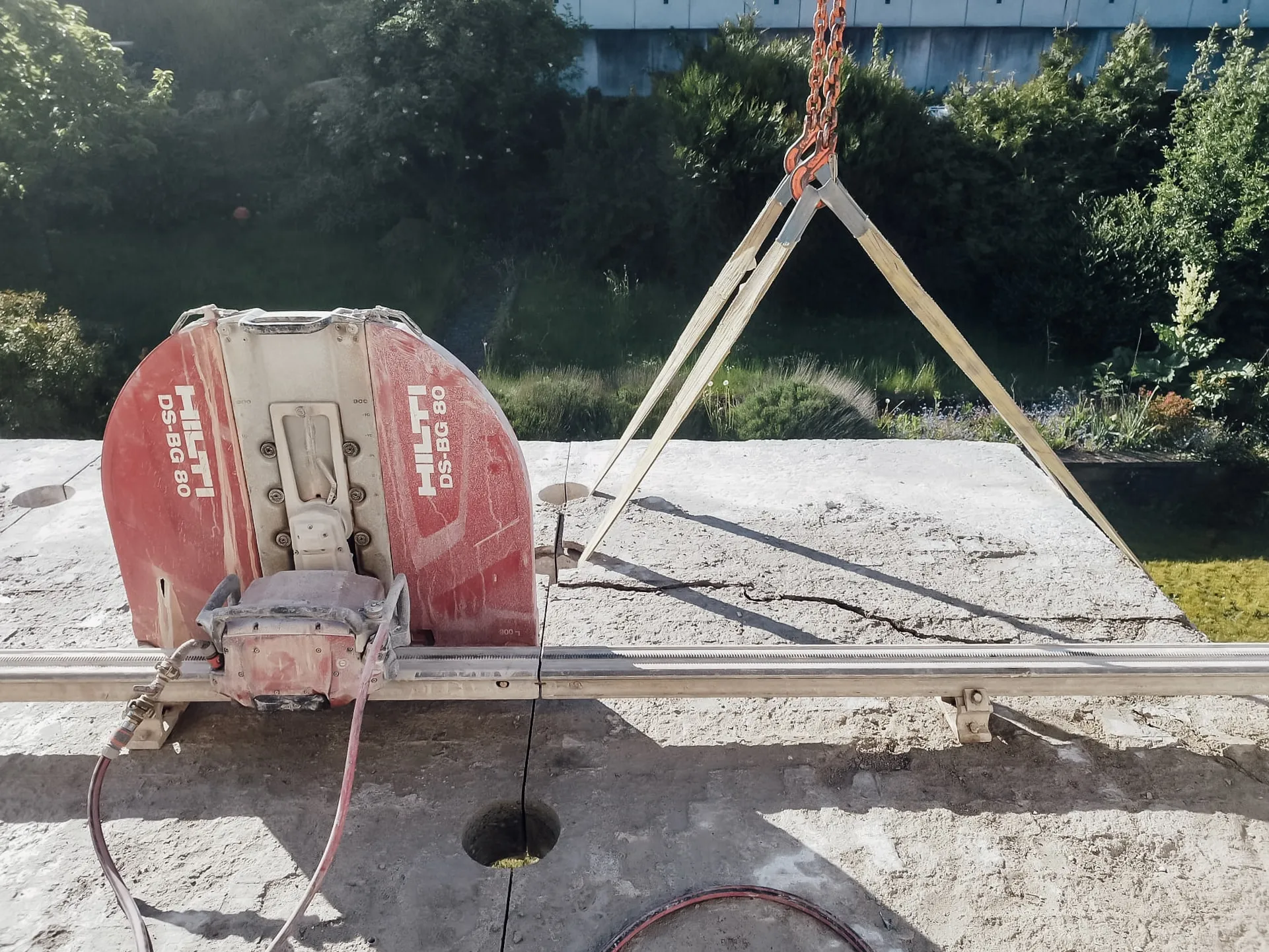 Wandsäge auf ihrer Führungsschiene auf einer Betonplatte im Freien